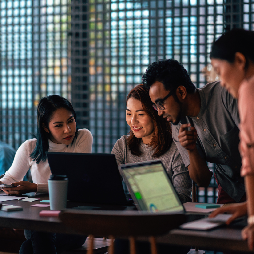 Group of people gathered around computer and analyzing data