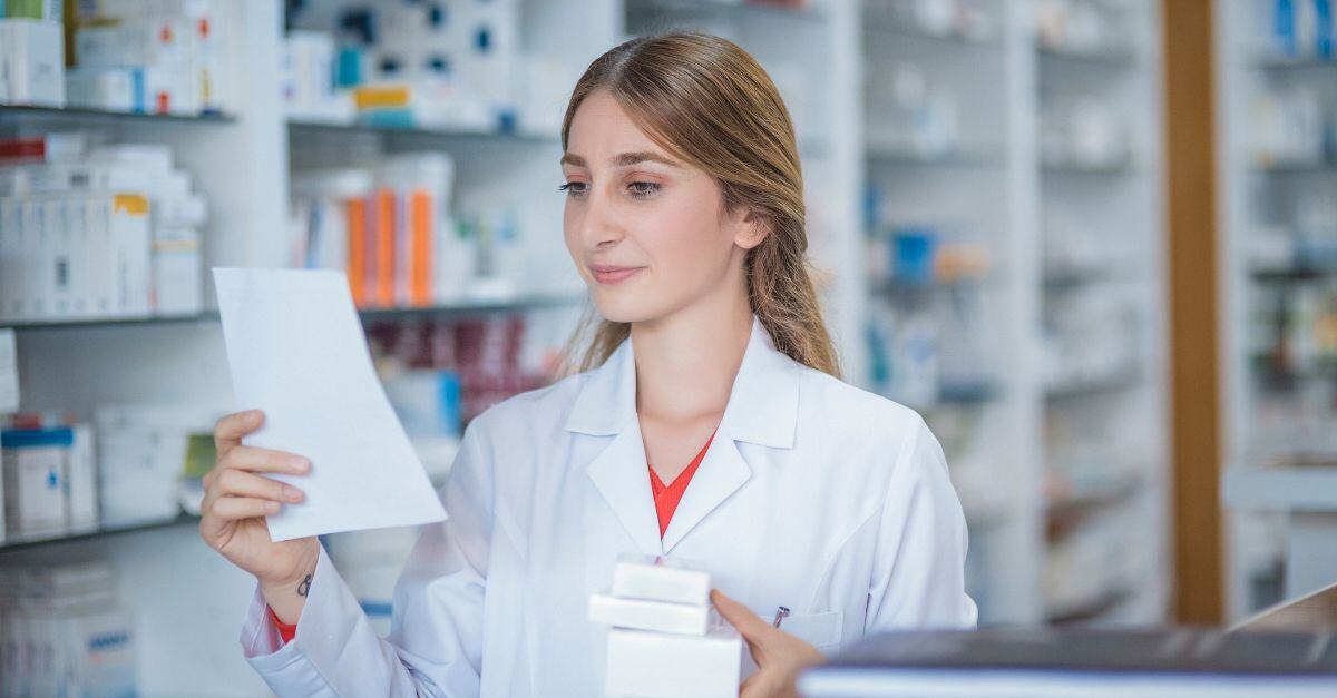 Pharmacist looking down and reading at prescriptions 